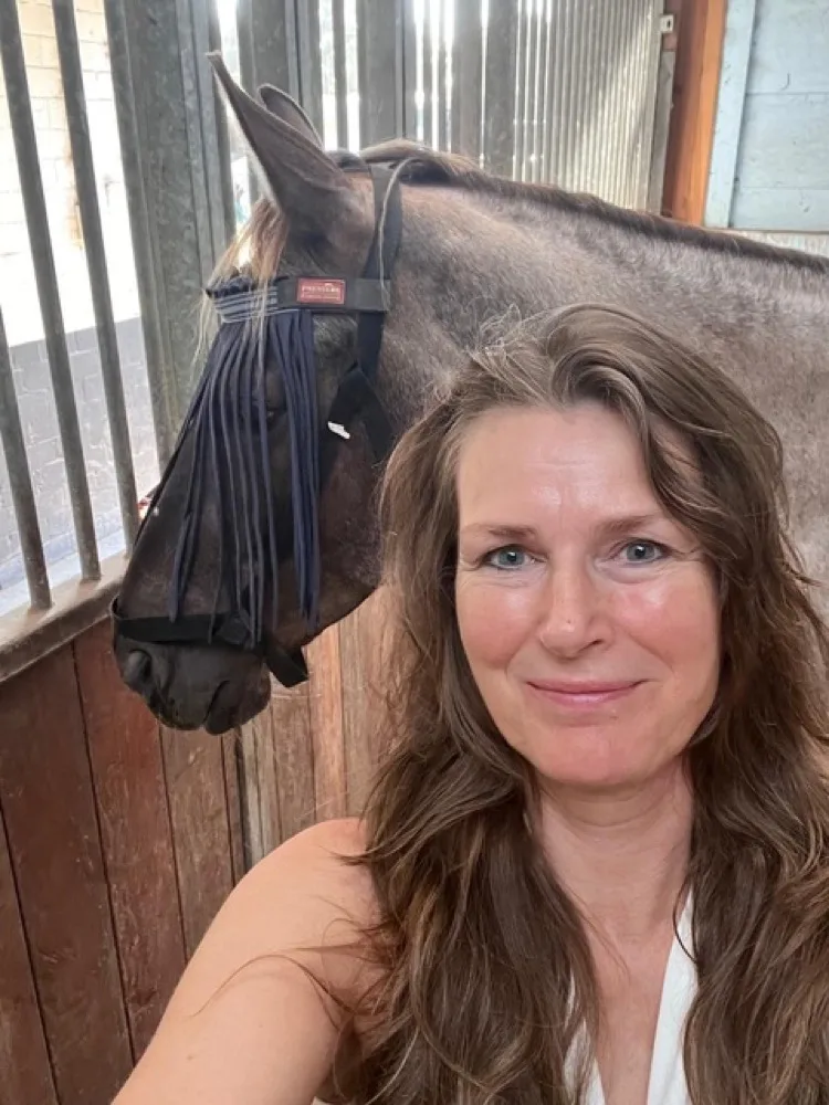 Edith Kuiper, met haar paard Camaro op stal